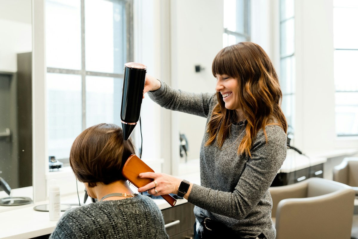 Coiffeuse réalisant un brushing